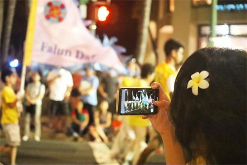 '图4：夏威夷法轮功学员的队伍路过时，观众用手机摄影留念。'