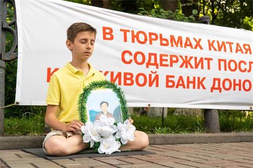 '图1～2：法轮功学员在基辅中使馆前抗议中共迫害'