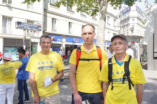 '图4：法国新学员约瑟（左）、皮埃尔（中 ）和塞巴斯蒂安三位学员准备参加反迫害二十年游行。'