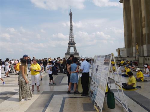 '图1：二零一九年七月七日下午，法轮功学员在巴黎铁塔边的人权广场，进行了法轮功功法演示、讲真相、揭露中共迫害罪行及征集签名反迫害的活动。'