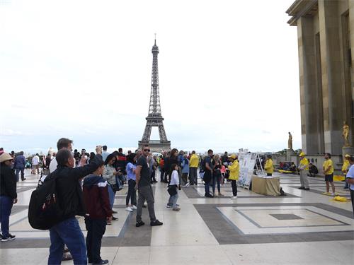 '图1：八月十七日星期日下午，法轮功学员在巴黎人权广场，进行了演示法轮功功法和讲真相的活动，吸引各国游人。'