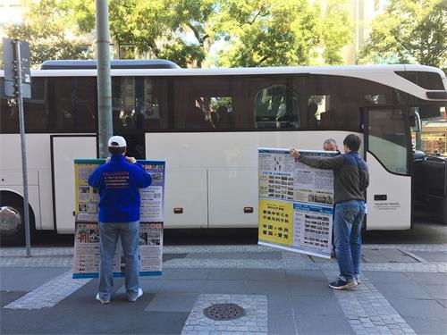 '图5：中国游客已上车，两位法轮功学员举着真相展板'