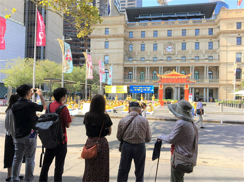 '图1：在悉尼市中心海关大楼前行人或游客驻足观看法轮功学员展示法轮大五套功法'