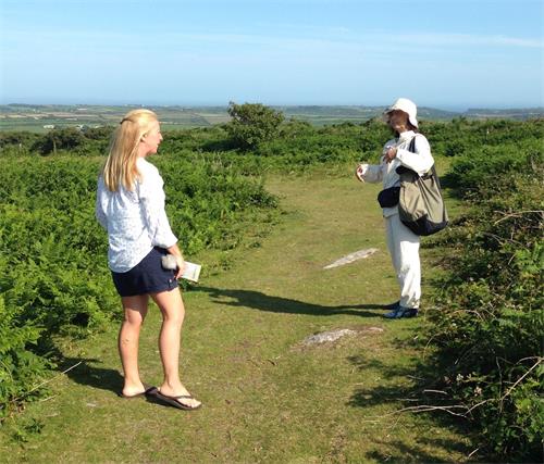 '图4：二零二零年六月二十三日下午，在青铜时代历史遗迹圣可里德高地（Sancreed Beacon）的田野上，法轮功学员鹤田缘（Yukari）向路遇的英国女士黛布拉（Debra，左）讲法轮功真相'