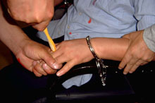 酷刑演示：牙刷钻指缝，将法轮功学员的五指并拢、捏紧，用牙刷柄在其指缝处用力转动。