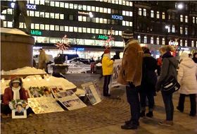 芬兰学员首都赫尔辛基市中心STOCKMAN购物广场前烛光悼念在中国遭迫害致死的法轮功，并揭露迫害。