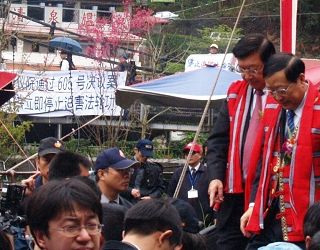 捐款仪式上，陈政高（右一）恶行被悬挂在后方吊桥。