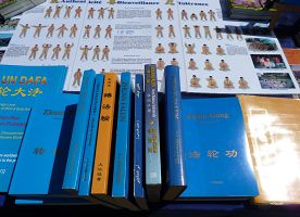 在真相桌上，法轮功学员摆放了被翻译成多种文字的法轮功书籍，及五套功法的介绍。