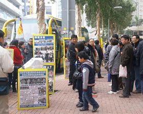 '许多中国大陆游客在嘉乐轩饭店前观看法轮功真相展板'