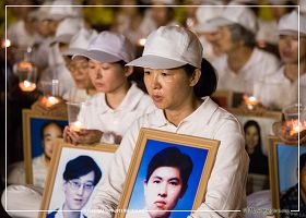 图9：法轮功学员手捧着被迫害致死的中国法轮功学员照片，表情静穆。