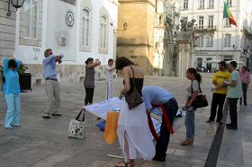 Coimbra的民众看真相展板和演示功法，签名支持反迫害