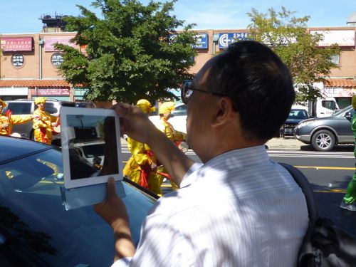 华人人用I-Pad记录法轮功游行的震撼场景。