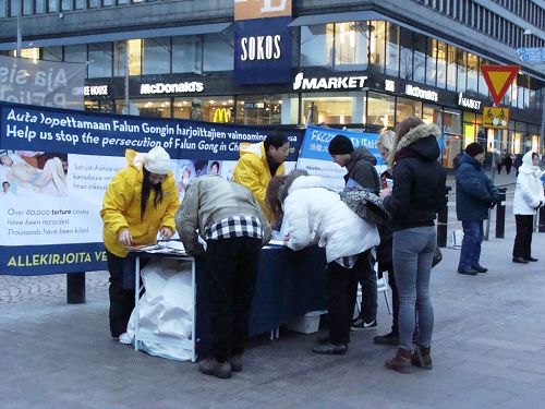图：法轮功学员在赫尔辛基火车站广场举行反迫害征签