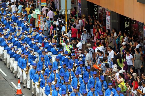 图7-11：香港法轮功学员二零一四年十月一日举行游行，队伍途经多个闹市区，吸引不少市民驻足观看。