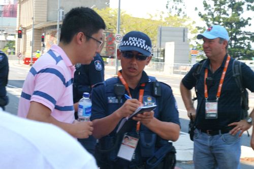 图5：中共派来干扰法轮功学员拉横幅的中国留学生们一一被澳洲警察要求登记护照内容，图为组织学生来的负责人之一正在被登记。