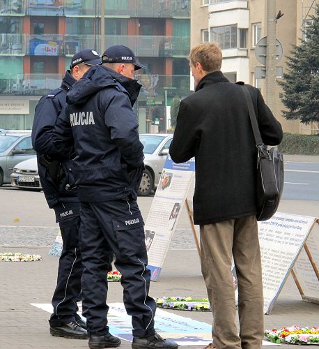 图5：华沙中使馆门前，法轮功学员为执勤警察讲真相