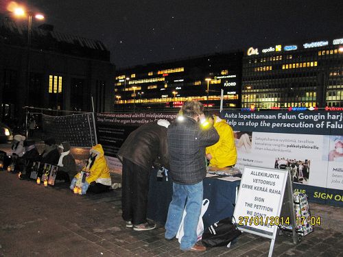 图：反酷刑纪念日，法轮功学员在芬兰首都赫尔辛基火车站广场举办烛光守夜活动