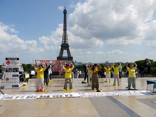 图1-5：巴黎学员在著名景点埃菲尔铁塔下的人权广场传播法轮功真相，吸引四方来客驻足了解。