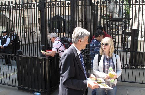 法轮功学员在英国首相府前，跟前来看热闹的人们讲述法轮功的真相。