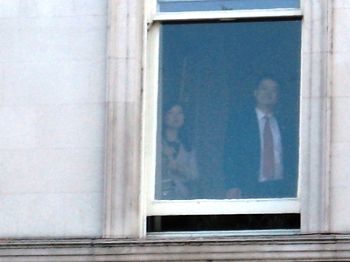 图5：外交部二楼的窗口，中方人员都在看马路对面法轮功学员抗议的横幅和场面