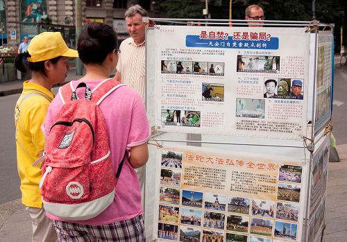 图4：中国游客阅读展板，了解“天安门自焚”真相