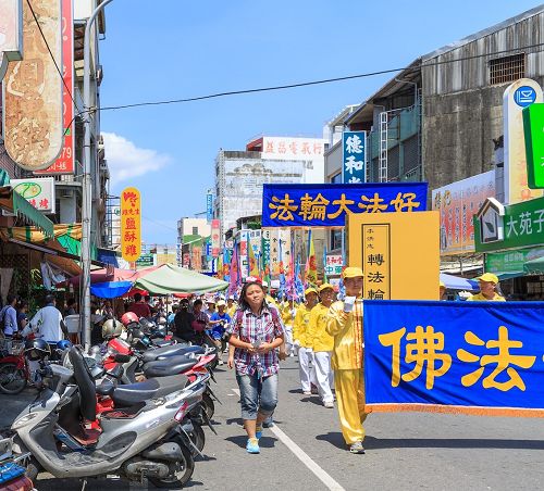法轮大法洪法队伍走过台南市主要的闹区和乡镇，吸引许多市民和乡亲走出来路旁，翘首迎接。