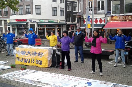 图：法轮功学员在阿姆斯特丹唐人街举办讲真相活动，演示功法