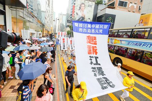 图：许多大陆游客被游行的巨大横幅标语”控诉江泽民”所震撼。