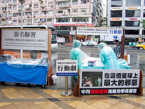 图1：台北法轮功学员在东区顶好商圈广场以真人模拟演示行动剧，揭露中共活摘器官贩售的暴行，并向路人征签举报江泽民的反人类罪行。