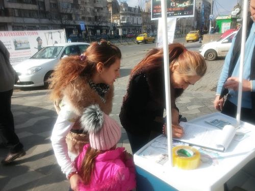 一位带着两个女儿的母亲在签名