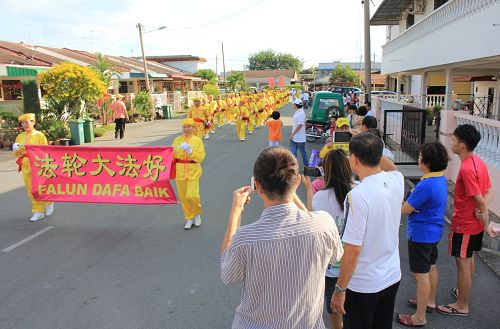 法轮功学员来到了彭亨州直凉举行新年游行，吸引了许多民众追随观看。