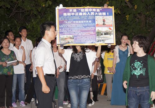 图3：二零一二年七二零，赵富玲（右）在高雄西子湾景点导演行动剧，向大陆游客传播法轮功真相。