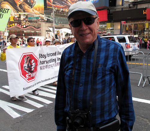 退休律师哈维•罗森加特（Harvey Rosengart）正在认真观看法轮功学员在纽约举行的盛大游行