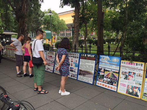 图7-9：法轮功真相吸引民众、尤其是中国大陆观光客的关注，并驻足观看真相。