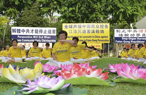 图1－2：反迫害十六周年，新加坡法轮功学员在芳林公园举办活动，传播法轮功真相，并将“诉江大潮”广告民众。