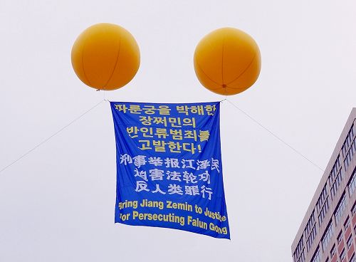图10：活动现场首尔广场上空飘扬着“刑事举报江泽民迫害法轮功反人类罪行”的大型气球。