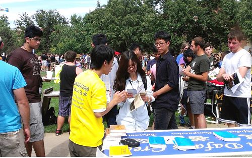 人们纷纷驻足询问了解大法的信息，包括一些华裔和大陆来的新生