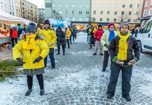 '图1～2：瑞典法轮功学员在林雪平（Linköping）市中心广场举行讲真相反迫害征签活动，学员们向民众演示法轮功的五套功法。'