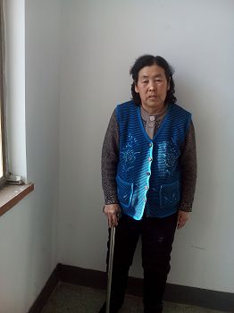 姜艳玲迫害致残后只能柱着棍慢慢行走，不能干家务活。