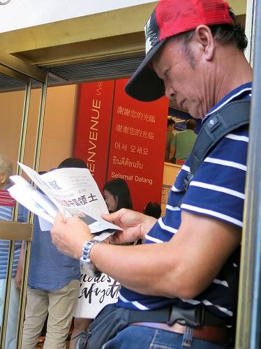 '图2：巴黎拉法耶特商店门前，大陆游客认真阅读《真相报》。'