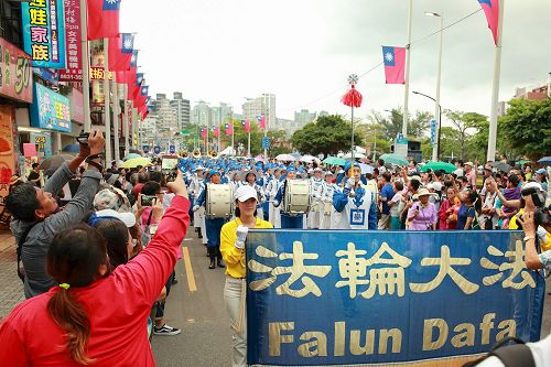 '图1：十月七日新北市举办淡水环境艺术节踩街活动，台湾法轮大法队伍最受瞩目，吸引数万民众驻足观看，并纷纷拿出手机拍照留影。'