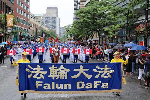 '法轮大法天国乐团，和旌旗、炼功队伍的法轮功学员共250多人应邀参加了蒙特利尔7月1日举办的加拿大国庆游行，受到东、西方观众盛赞。'