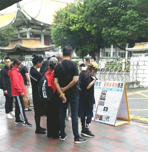 '图1～4：台北国父纪念馆前，大陆游客认真阅读法轮功真相展板'