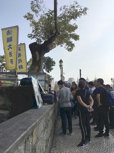 '图1～4：中国大陆游客在澳门景点认真阅读法轮功真相展板'