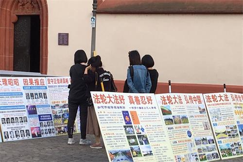 '图7：在真相展板前仔细阅读的中国游客'