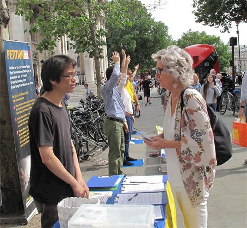 图10：二零一八年六月二十三日，在伦敦圣马丁广场，想学功的苏珊（Susan）向法轮功学员深入了解真相。