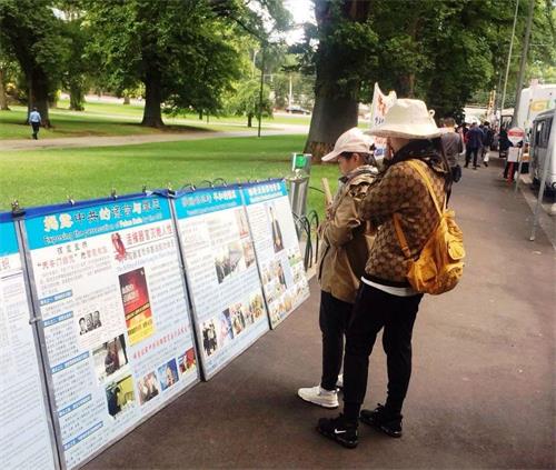 墨尔本市中心著名景点费茨罗伊公园是大陆游客了解法轮功真相的窗口。图为中国新年期间，大陆客在阅读摆放在公园入口处的大法真相展板。