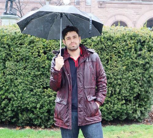 '图10：国际留学生Omar经过法轮功学员集会地方时，停在法轮功学员旁边聆听完加拿大议员讲述发生在中国的迫害。'
