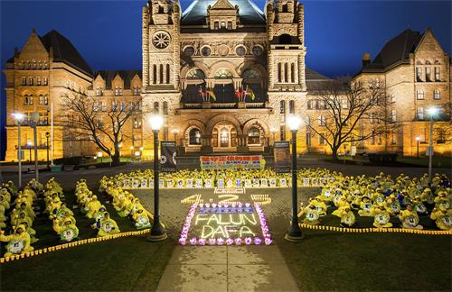 '图1：二零一九年四月二十日晚上八点至十点，多伦多法轮功学员在安省议会大楼前举行烛光夜悼念，悼念被中共迫害致死的同修。'