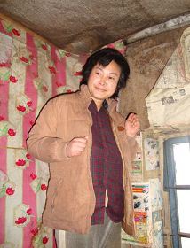 񟭊年图片：被迫害致疯的柳志梅，当有人试图接近，她就攥着双手躲向自家墙角'
